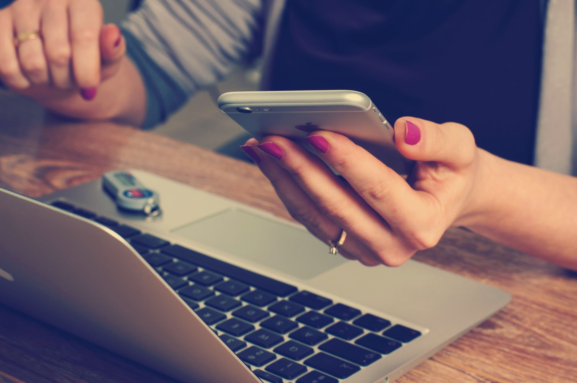 feminine hands with phone and laptop